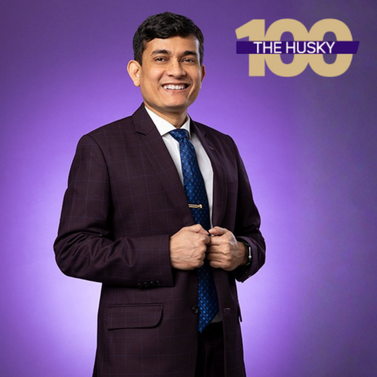 Mohammad Gazi wearing professional attire next to the Husky 100 logo.