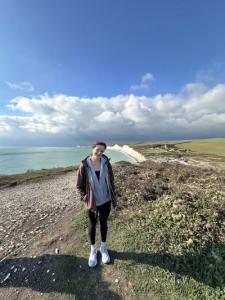 Women standing on green space with the sea in the background
