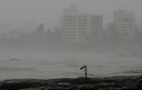 Photo of a man standing by the sea during heavy rain showers in Mumbai