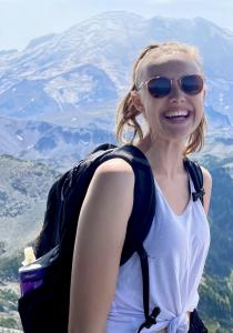 MPH student Quinn Peters smiles at the camera while hiking