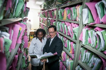 Photo of Dr. Michael Chung reviewing patient records with a colleague at Coptic Hope Center in Nairobi, Kenya