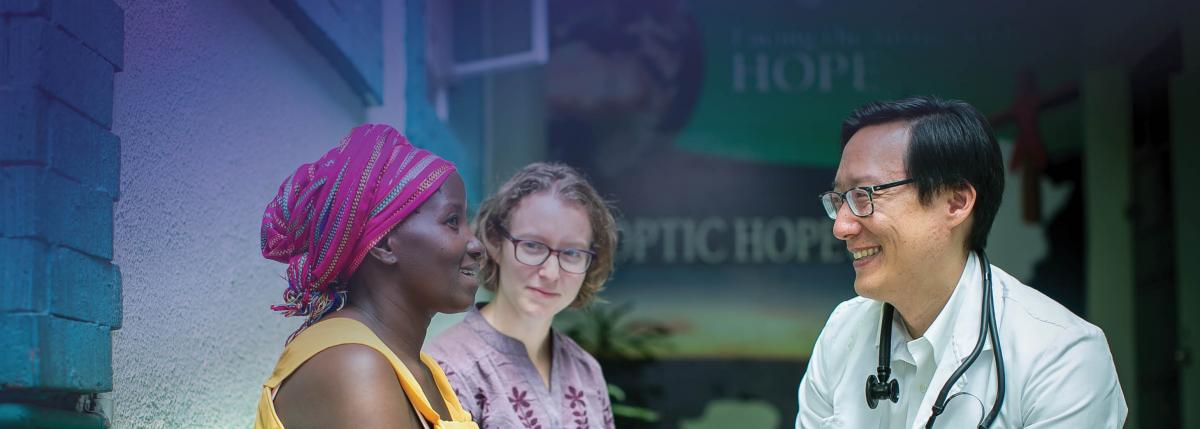 Photo of Dr. Michael Chung, Director of TREE, and Sharon Greene, a PhD student in Epidemiology, talking with a patient at the Coptic Hope Center in Nairobi, Kenya.