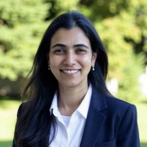 Headshot of Anita Shet wearing professional attire in a grassy area.