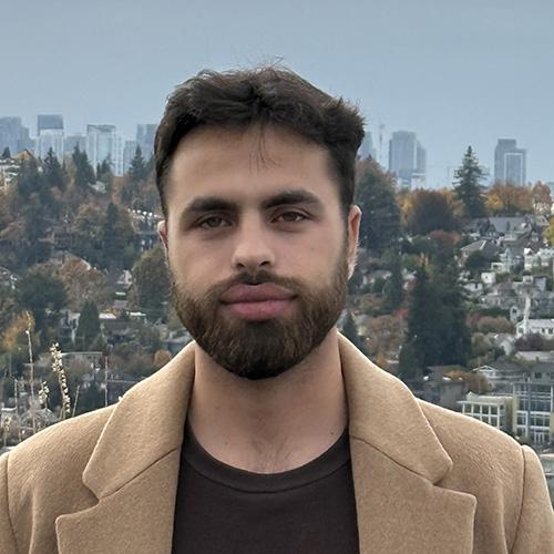 Headshot of Husam Alattar wearing a tan peacoat.