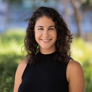 Headshot of Jennifer Velloza wearing professional attire outside.