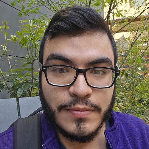 Headshot of Ricardo Moreno Garcia wearing a purple shirt and backpack.