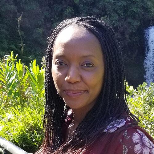 Headshot of Salome Marimbet wearing a purple and white floral shirt.