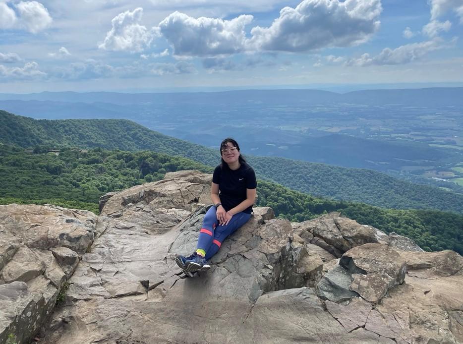 Guoyue sitting on a ledge in nature.